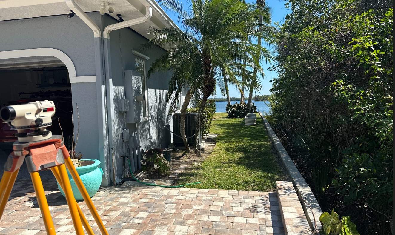Equipment on tripod set up to survey elevation of a home